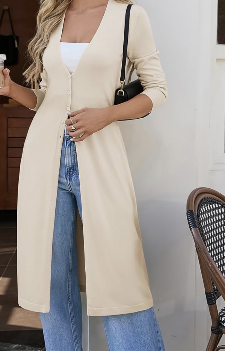 Long cream button-front cardigan layered over white tank with wide-leg jeans